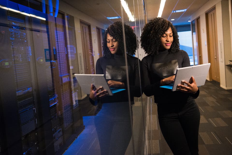 Two engineers with laptops in a data centre server room